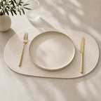 Alabaster oval cotton cord table mat styled with ceramic plate and gold cutlery